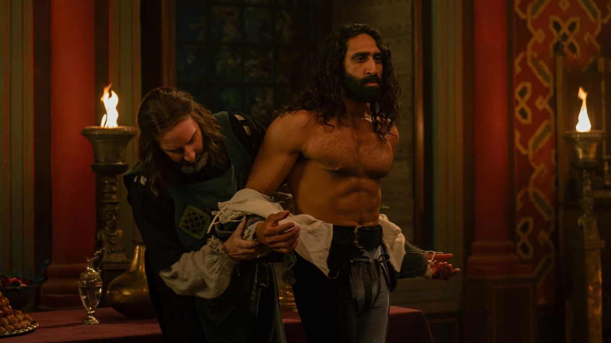 Tony Hale as Sirisco takes the clothes off of Amar-Chadha Patel as Dioneo in The Decameron