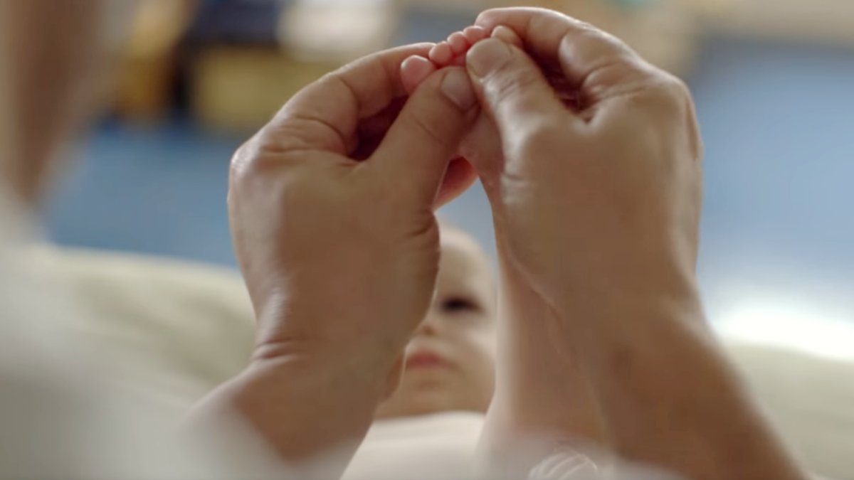 Adult hands holding a baby's foot