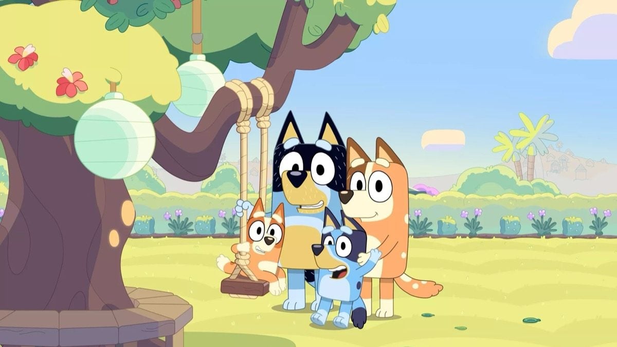 A family of dogs stands by a swingset in "Bluey"