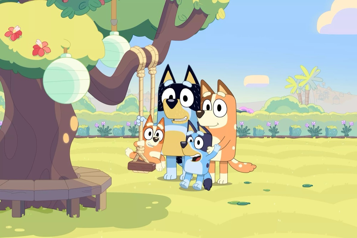 A family of dogs stands by a swingset in "Bluey"