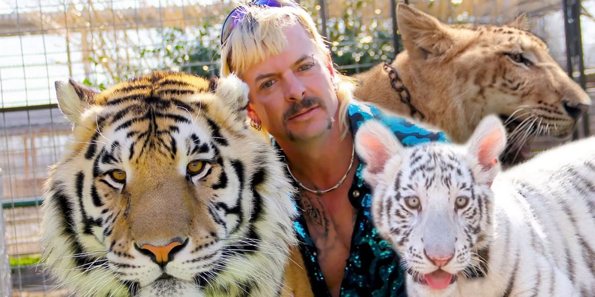 Joe Exotic poses for a photo with three tigers in "Tiger King" (Netflix)