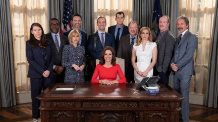 The full cast of Veep standing behind resolute desk in Oval Office