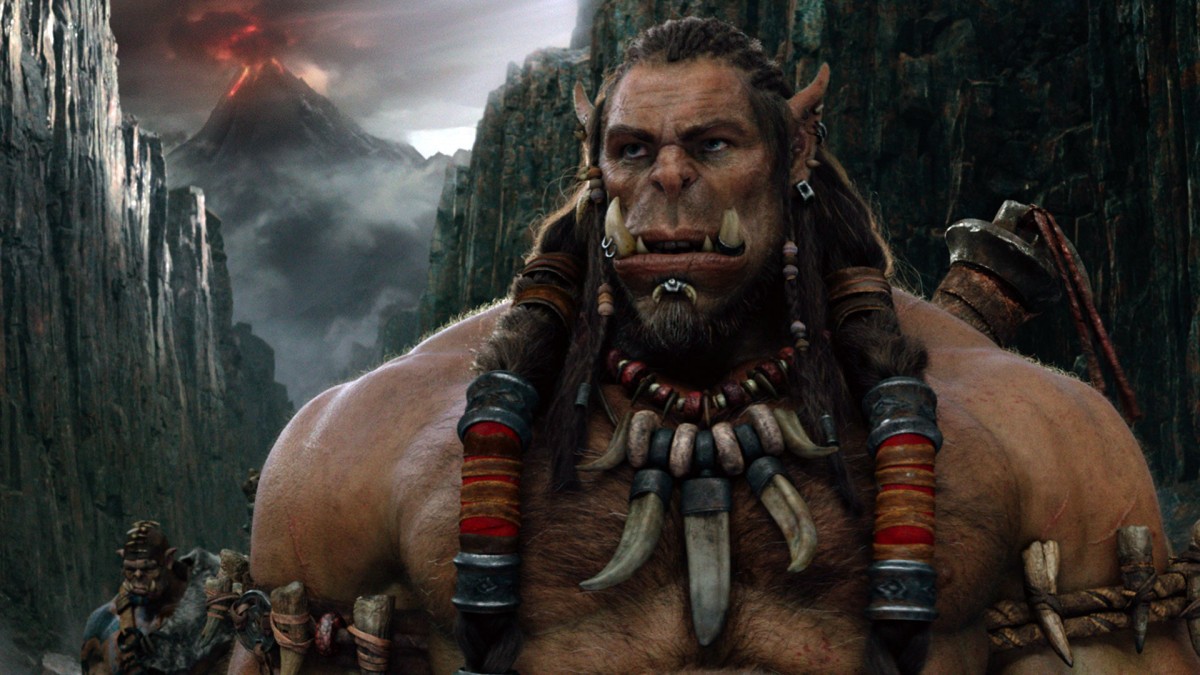 An orc from "Warcraft" stands stoic in a canyon