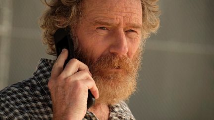 A bearded man looks perturbed on a phonecall in 