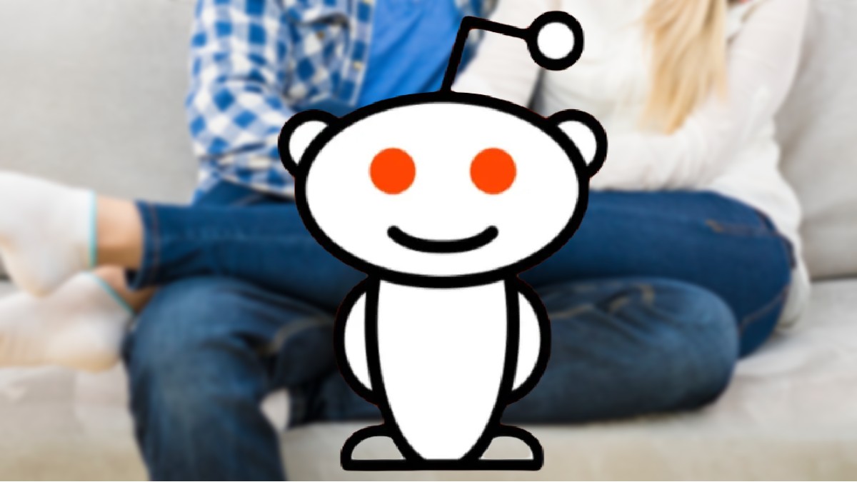 A blurred cropped photo of a couple cuddling on a sofa, with the Reddit mascot overlaid