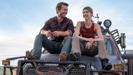 Daisy Edgar Jones and Glen Powell sitting on a truck