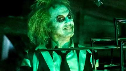 A close up of Michael Keaton's Betelgeuse in glowing green light in Beetlejuice, Beetlejuice