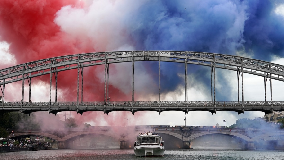 Paris Olympics opening ceremony smoke in the colors of French flag.