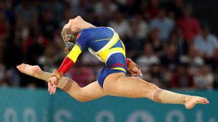 Sabrina Maneca-Voinea of Team Romania does a mid-air splits during the Olympic finals.