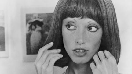 A close-up on a young Shelley DuVall's face in black and white