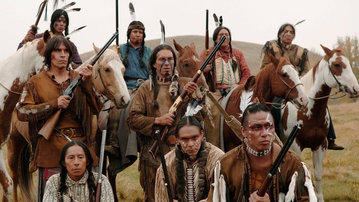 A group of Native Americans hold rifles in "Bury My Heart At Wounded Knee"