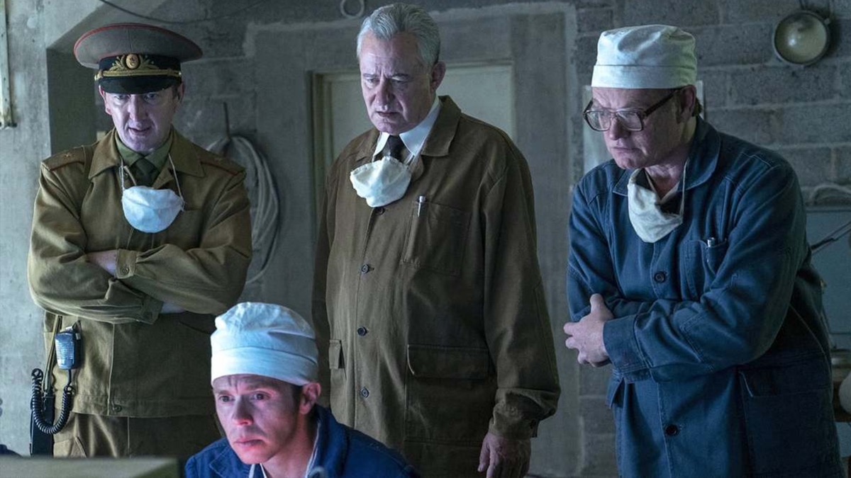 Four men in PPE stand looking perturbed in "Chernobyl"