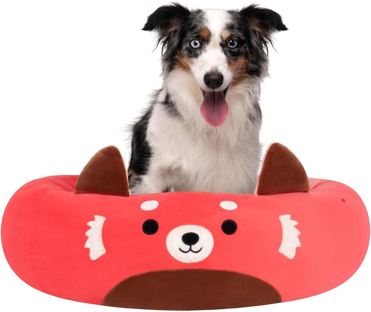 A dog sits on a Cici The Red Panda Pet Bed