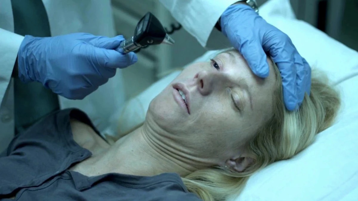 A doctor looks into the eyes of a non-responsive woman in "Contagion"