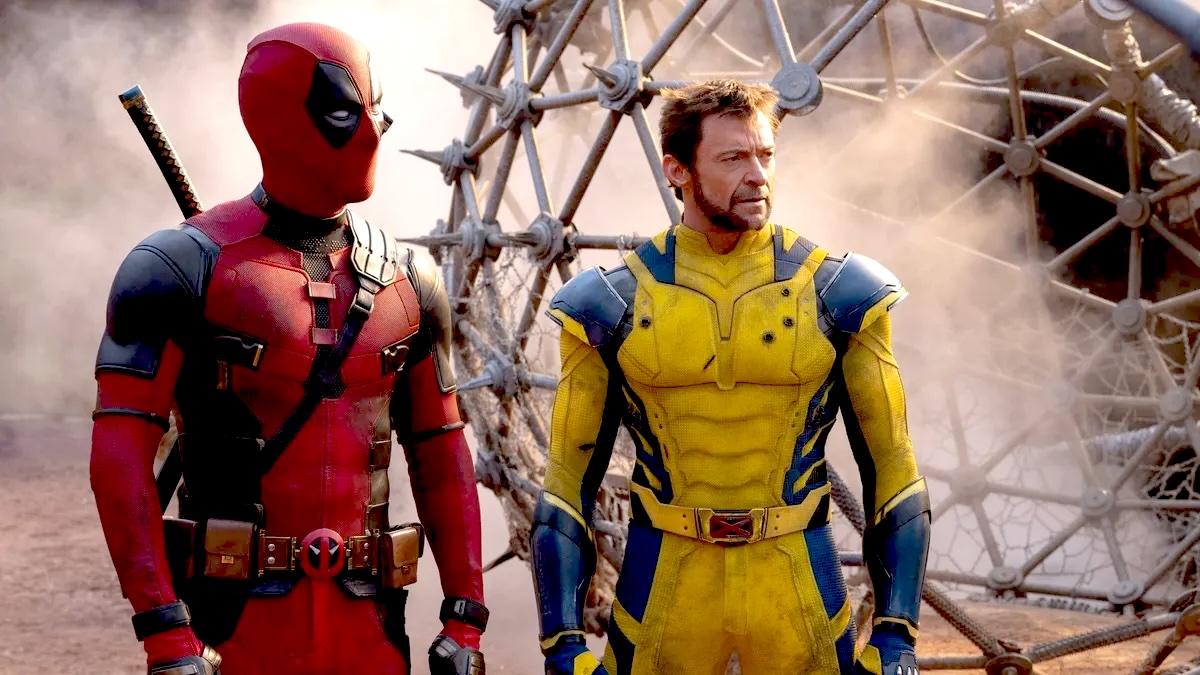 Deadpool (Ryan Reynolds) and Wolverine (Hugh Jackman) stand side by side in front of a spiked circular cage