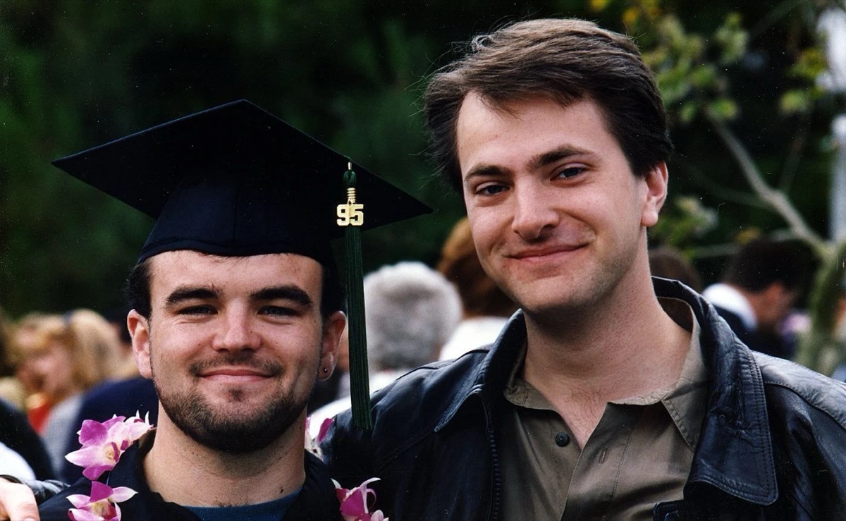 Two young men stand together at a high school graduation in "Dear Zachary- A Letter to a Son about his Father"