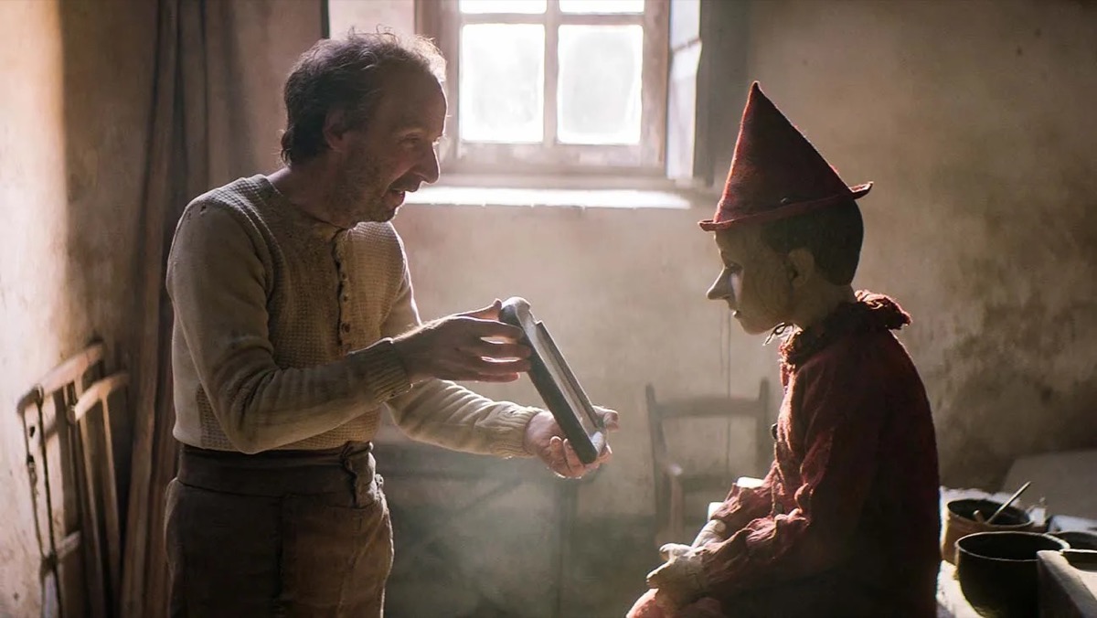 A father shows a picture t his son who is dressed as a clown in "Life is Beautiful" 