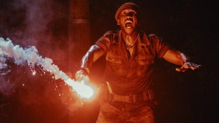 Mahershala Ali holding a flare in Jurassic World Rebirth