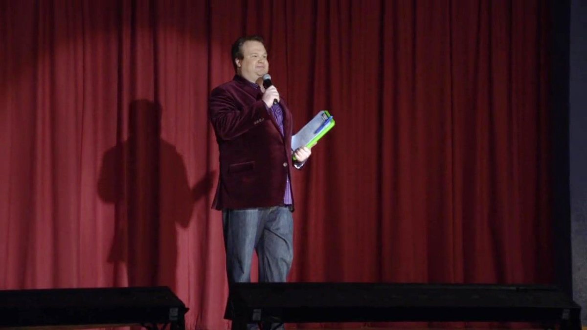 Cam (Eric Stonestreet) on stage