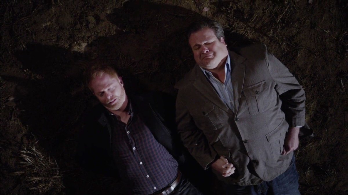 Mitchell and Cameron (Jesse Tyler and Eric Stonestreet) lying on the ground