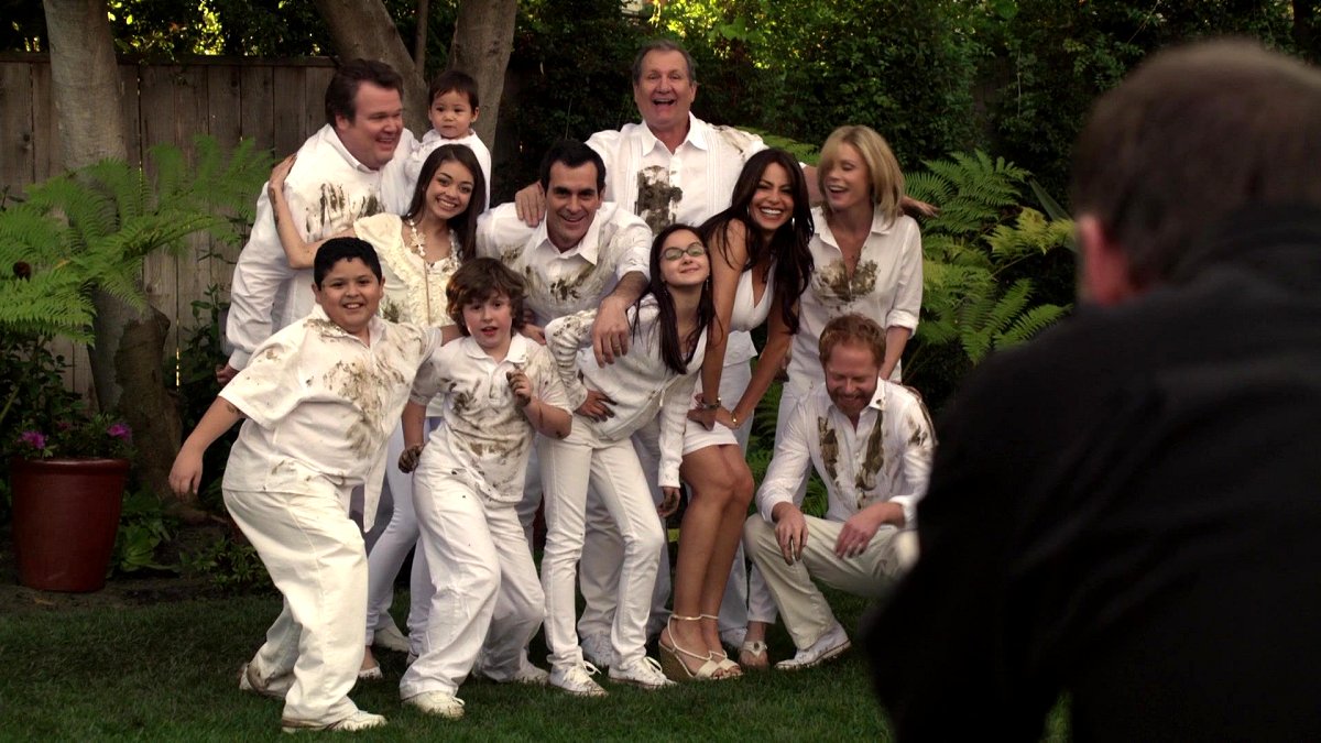 The family poses for a portrait, covered in dirt