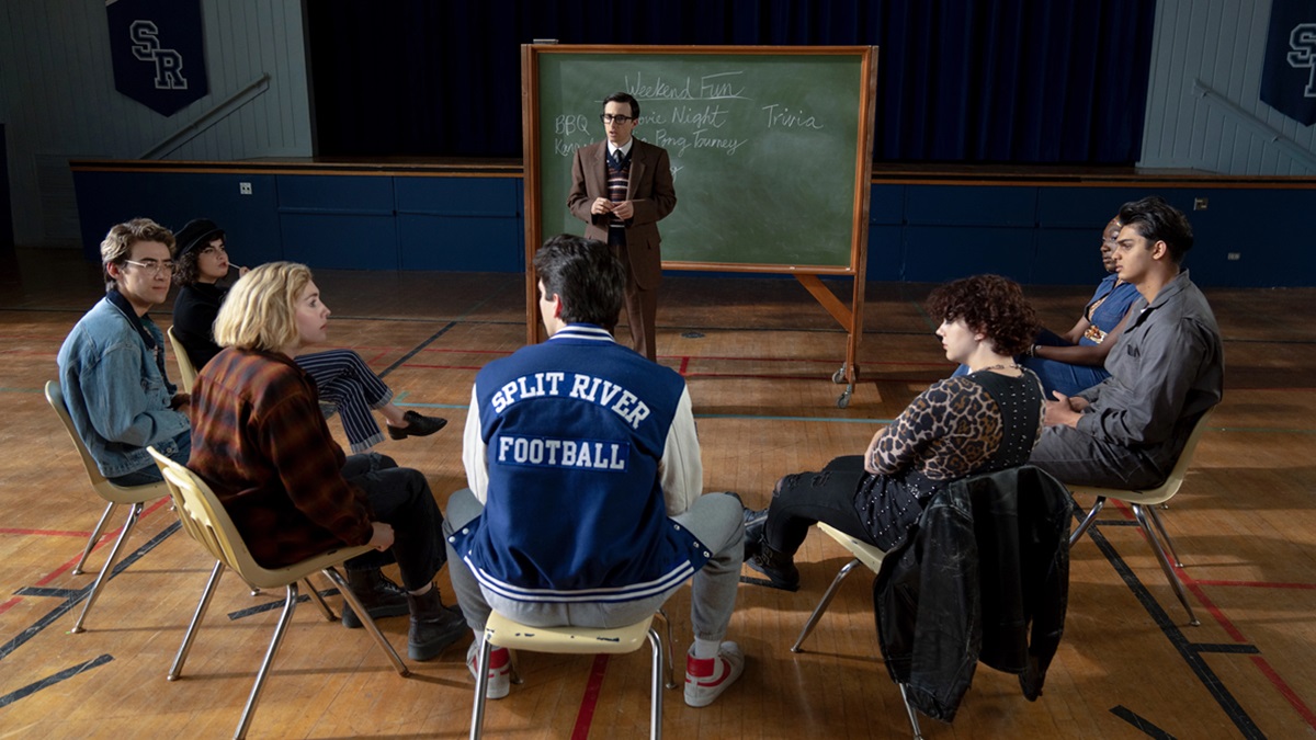 a group of students sit in a circle in the gym