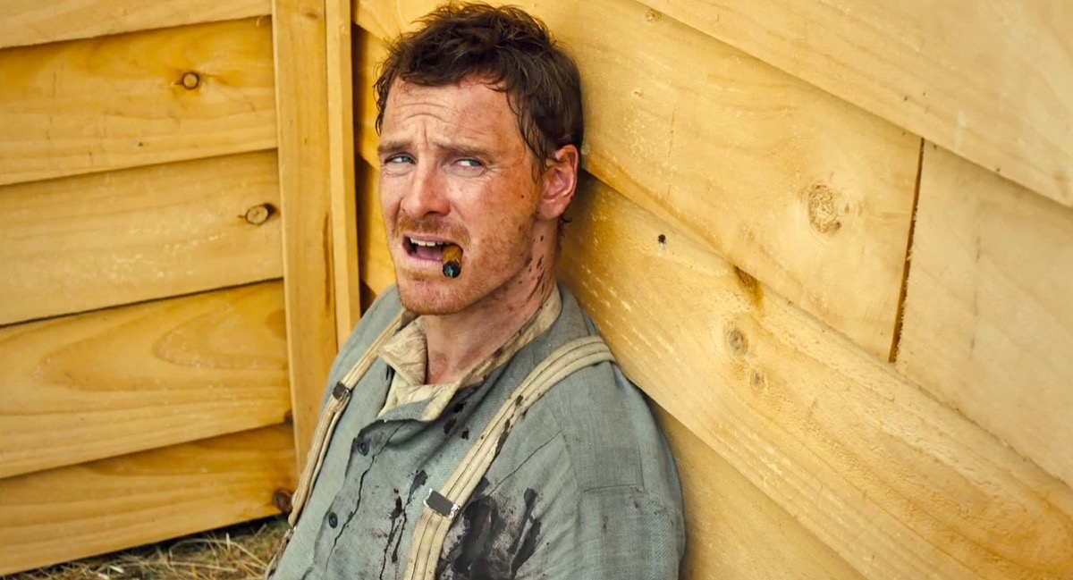 A gunslinger sits bloodied against a wall in "Slow West" 