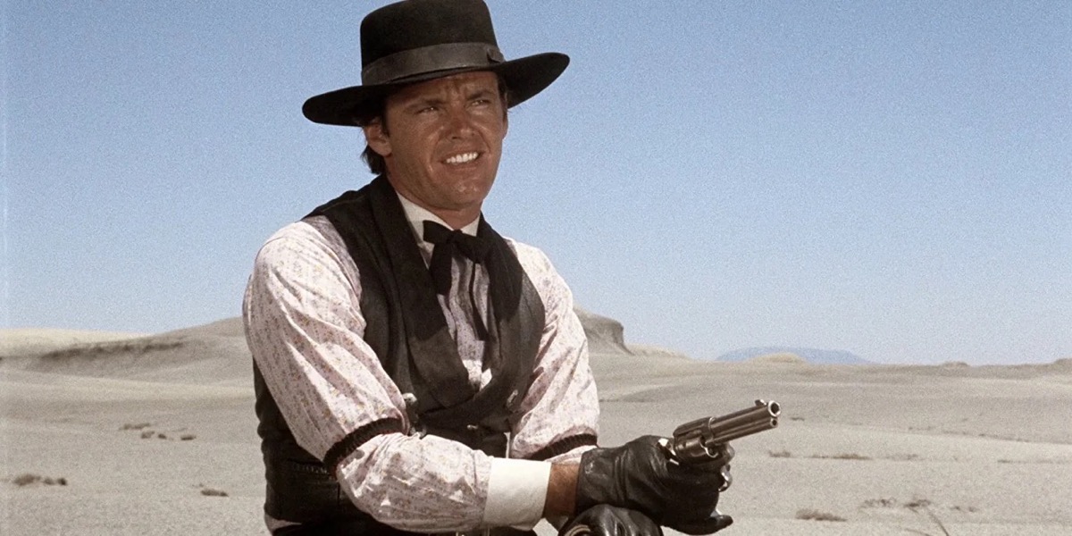 A man in the desert holds a shotgun in "The Shooting"