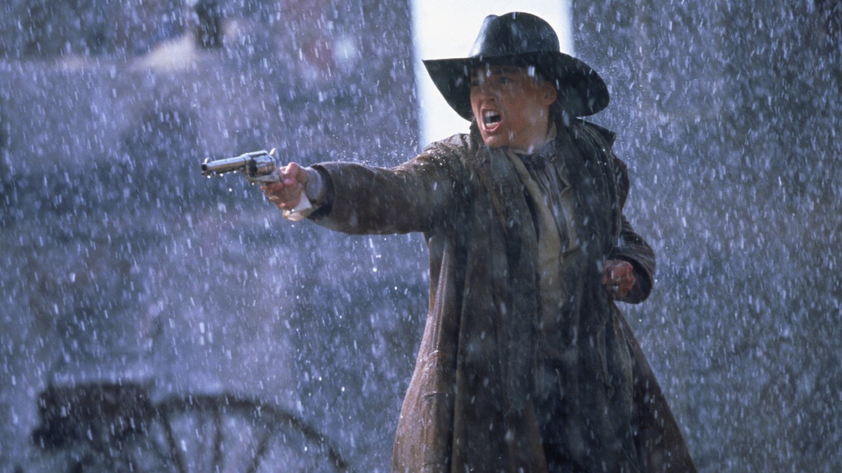 A gunslinger levels a revolver in the rain in "The Quick and The Dead "