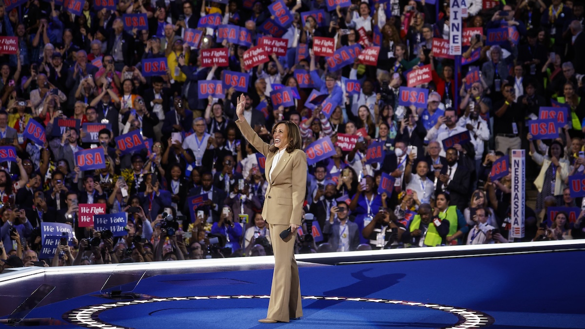 Kamala Harris standing at the center of the stage at the DNC