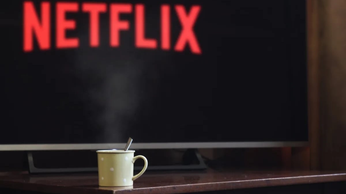 Netflix logo on TV and mug sitting on a table.