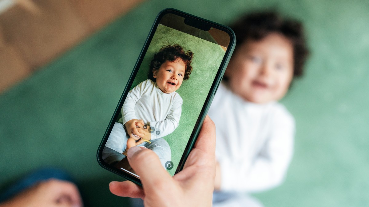 A person takes a photo of a baby on a smartphone