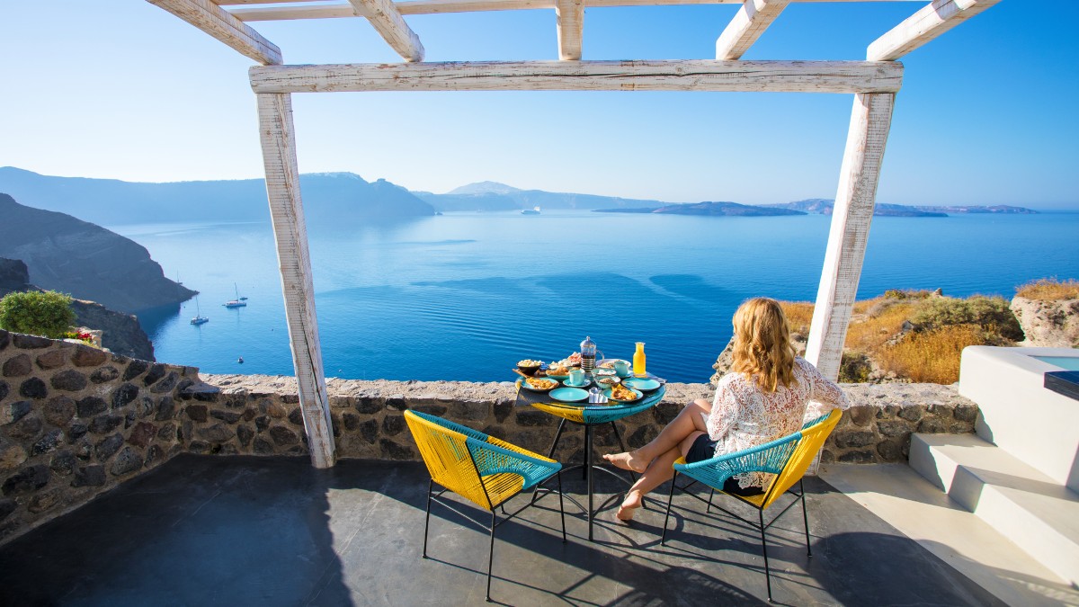 A woman enjoys breakfast with a view in Santorini