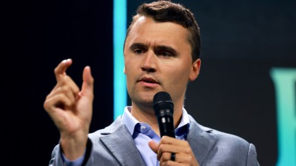 Charlie Kirk looking confused while speaking at a Turning Point USA conference