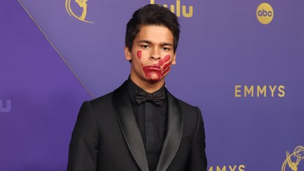 D’Pharaoh Woon-A-Tai in a tux with a red paint handprint on his face on the Emmys red carpet.