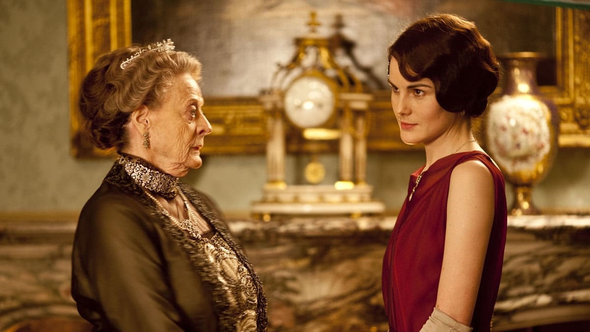 Violet speaks to Mary in front of a golden clock