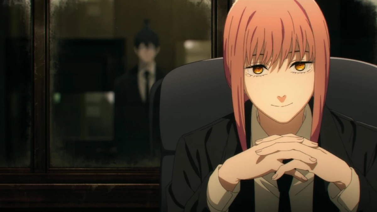 A red haired woman sits at a desk with arms folded in "Chainsaw Man"