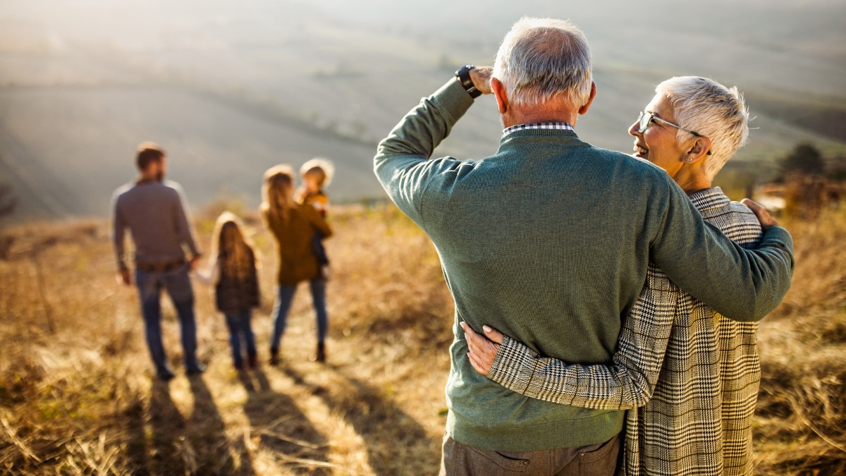 Grandparents watch a young family from a distance