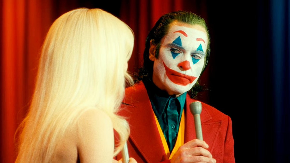 Joaquin Phoenix in Joker: Folie Á Deux, holding a microphone