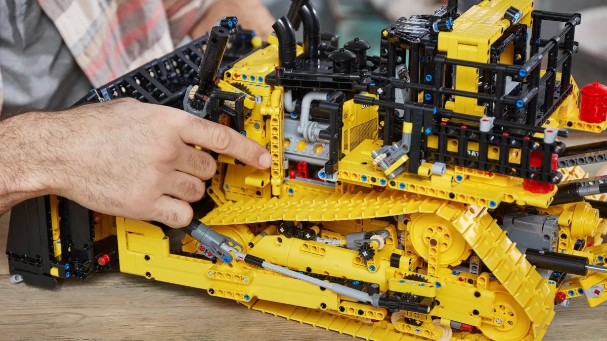 A man constructing a LEGO bulldozer