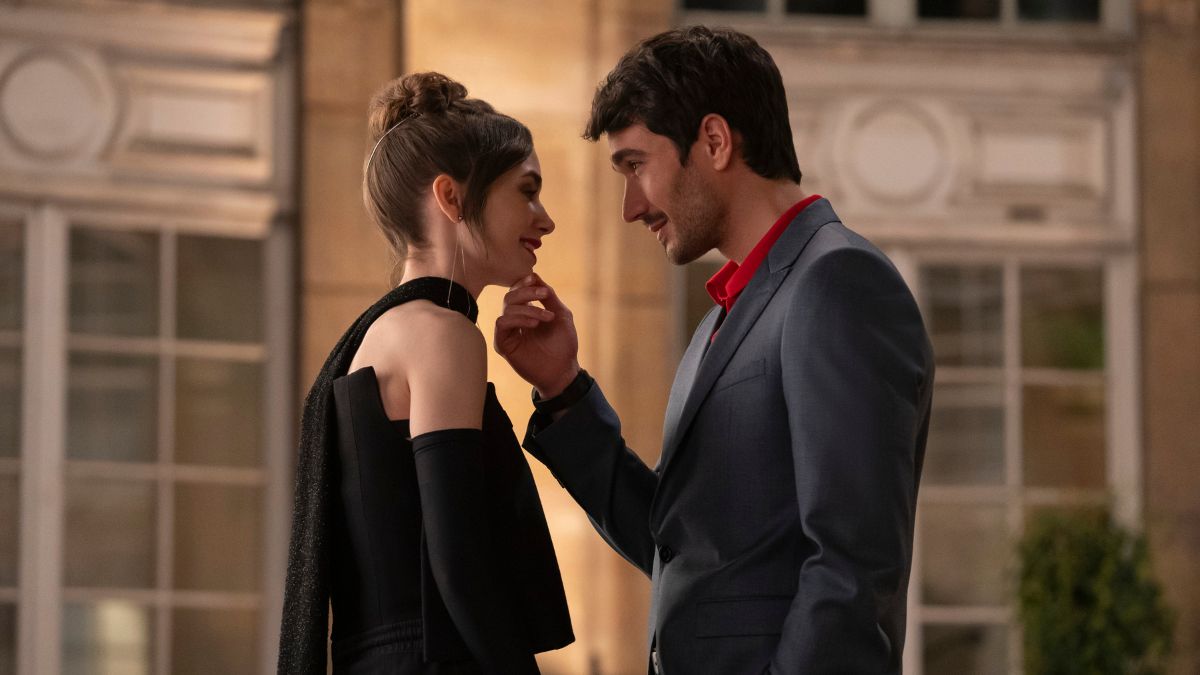 Eugenio Franceschini as Marcello Muratori lifts up the chin of Lily Collins as Emily in Emily In Paris season 4 part 2