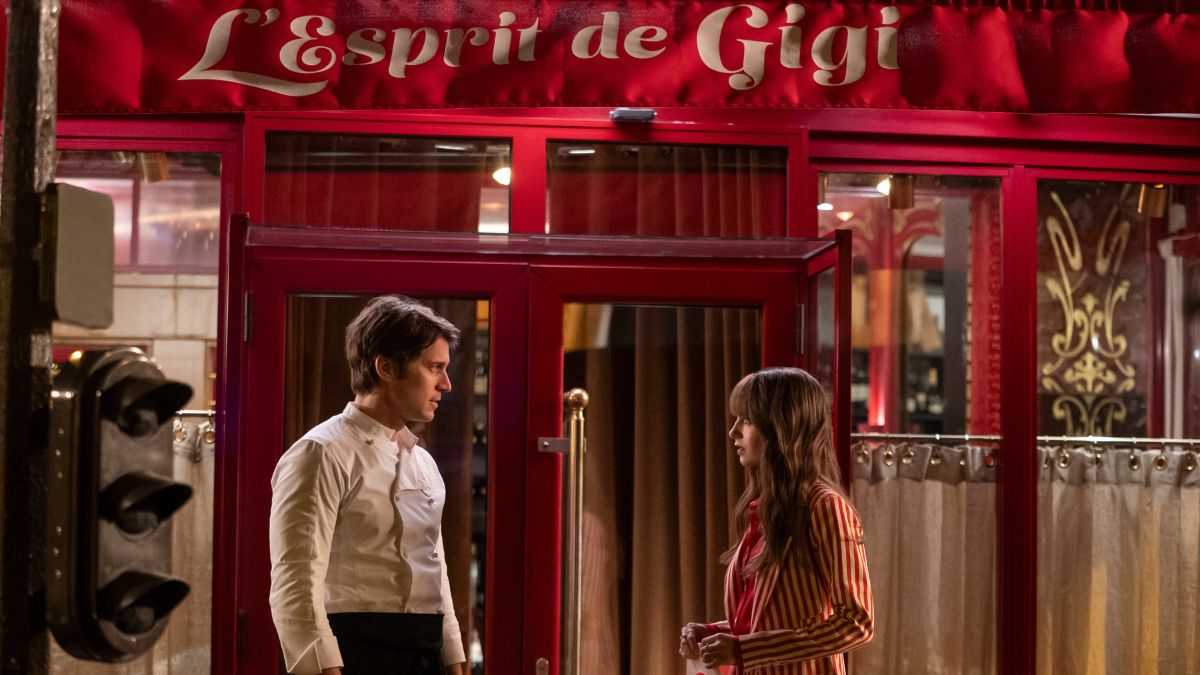 Lucas Bravo as Chef Gabriel and Lily Collins as Emily stand outside his restaurant in Emily In Paris