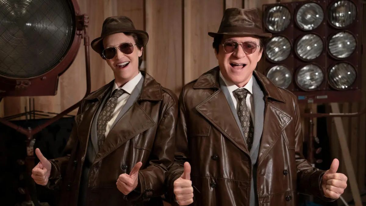 Jane Lynch as Sazz Pataki and Steve Martin as Charles-Haden Savage dress in identical leather coats, hats, and sunglasses in Only Murders in the building