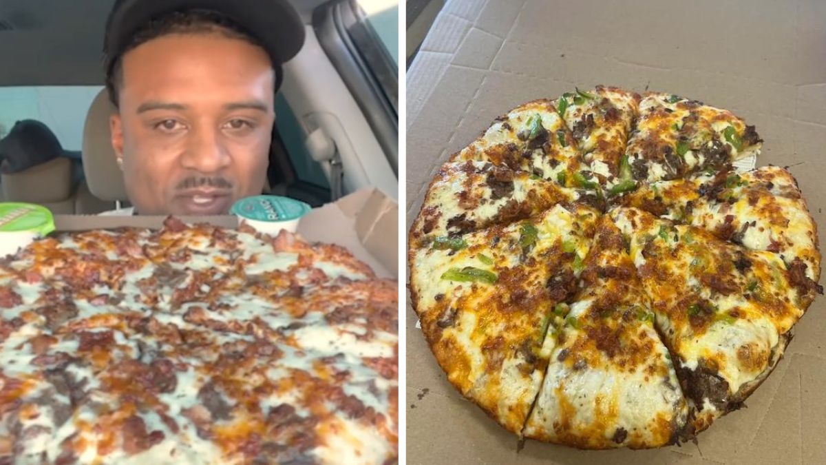 a man holds up a loaded pizza