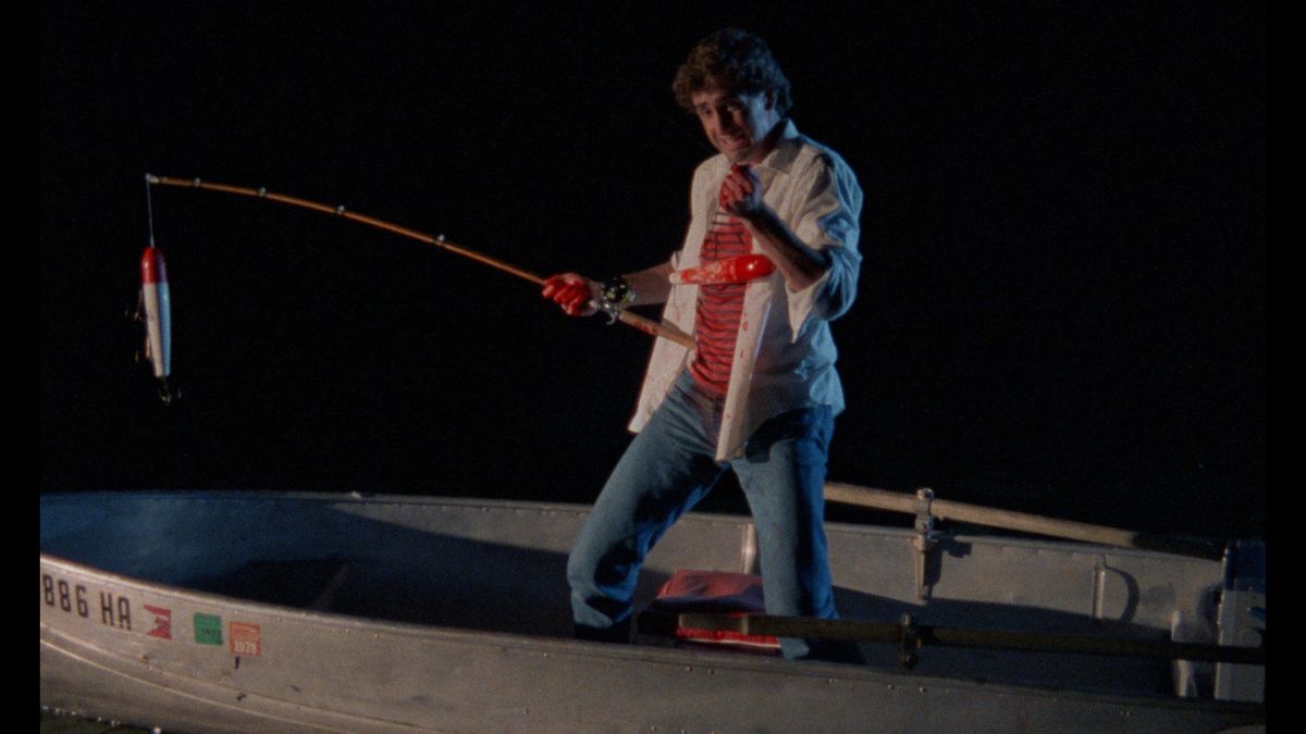 A man holding a fishing pole on a boat in Blood Hook.