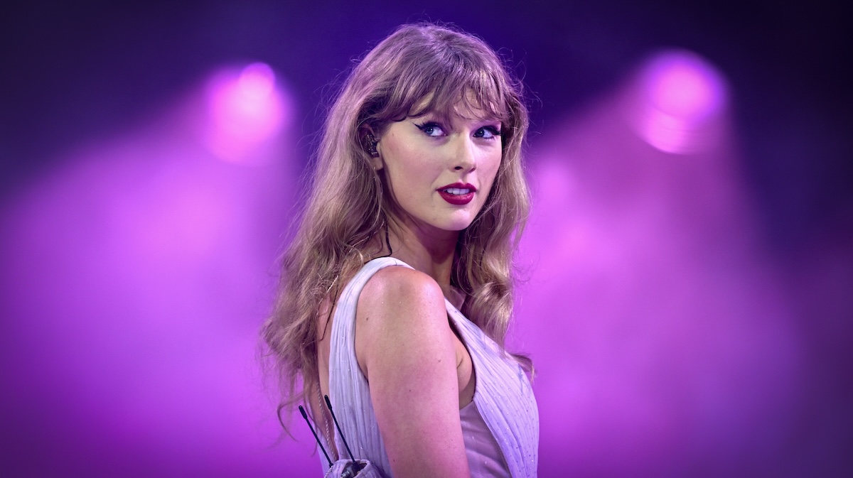 Taylor Swift looking over her shoulder on stage.