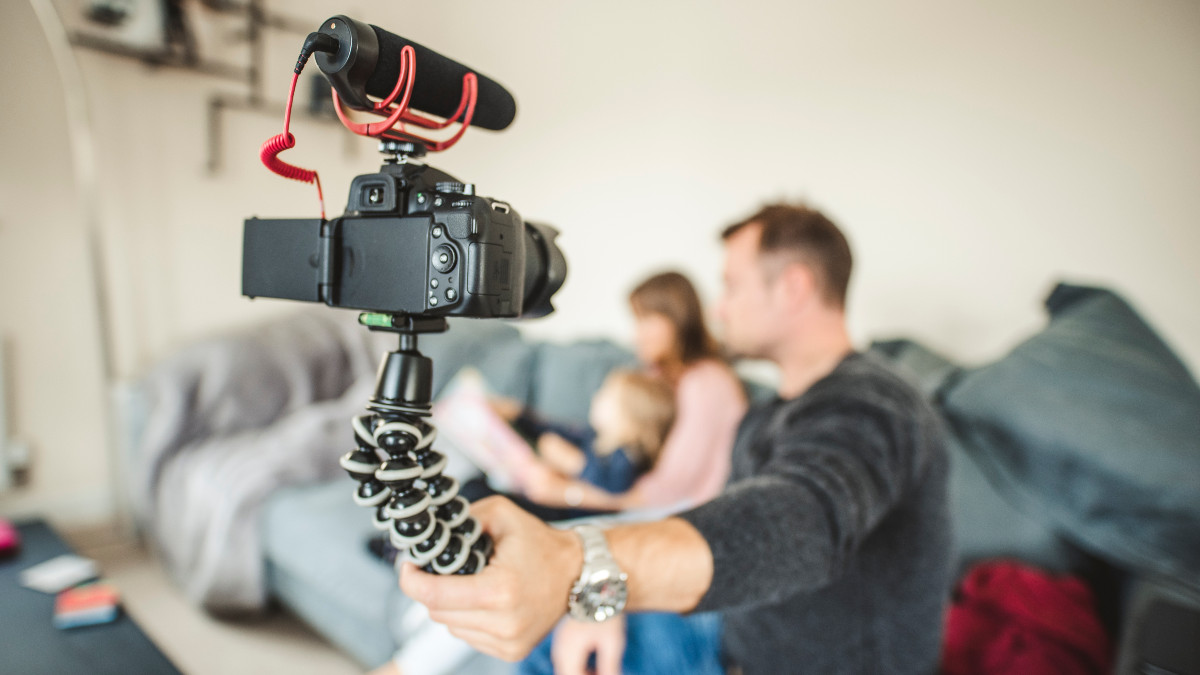 Familly vlogging themselves on the sofa - stock photo