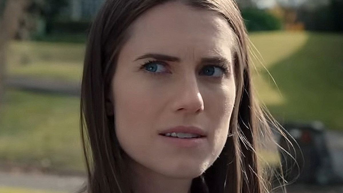 Image of Allison Williams as Gemma in a scene from 'M3GAN.' She is a white woman with long, dark hair standing outside looking off to the right.