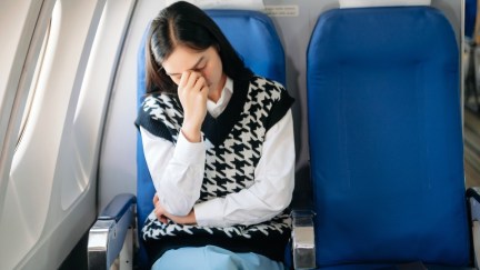 A woman looks annoyed on a plane