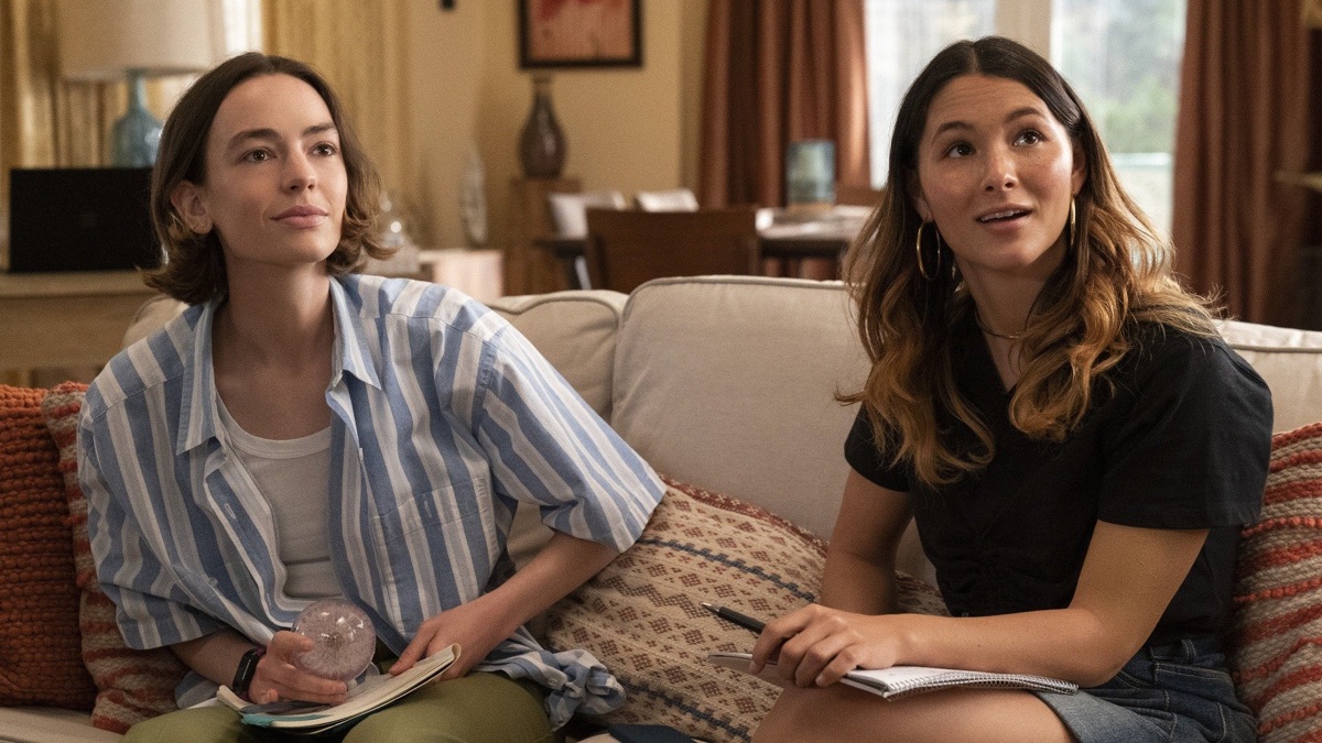 Two teenage girls sit one a sofa in a bright room in "Atypical" 